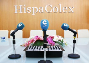 Tres microfonos de la emisora de radio COPE y de fono la pared con unas letras "HispaColex" en relación al programa de radio "Granada Empresas" que realizan en común